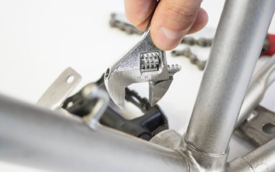 Eine Hand mit Schraubenschlüssel repariert ein Fahradlager